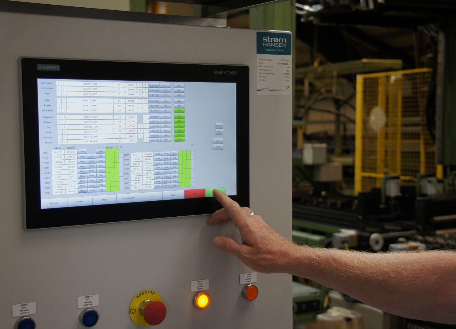 Operatør betjener ny Siemens SIMATIC HMI-panel med receptstyring på Elcolds moderniserede produktionslinje – leveret af Strøm Hansen
